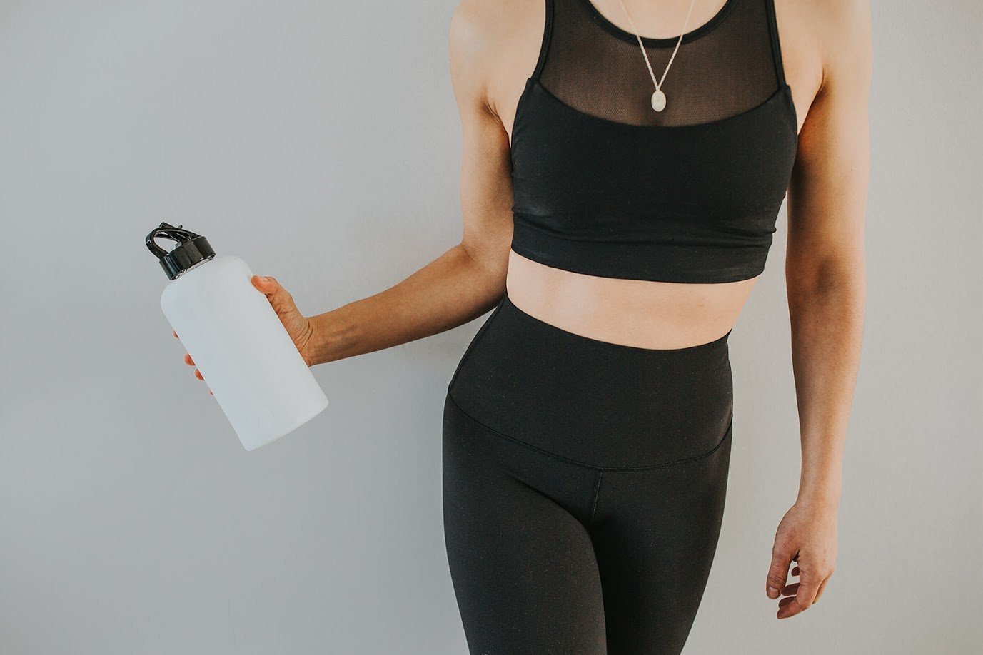 1L glass water bottle with white protective silicone sleeve and high gloss black lid in a workout setting - lifewithPandJ