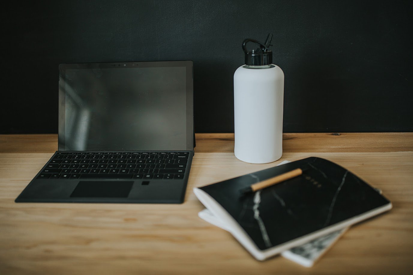 1L glass water bottle with white protective silicone sleeve and black folding straw lid in an office setting - lifewithPandJ