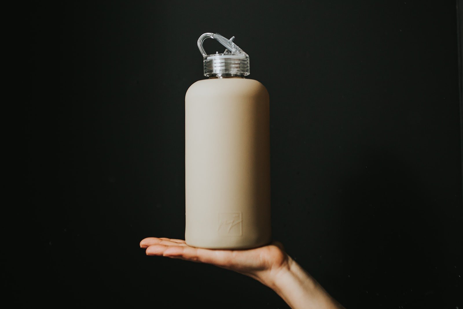 One litre glass water bottle with nude, sand coloured protective silicone sleeve and clear folding straw lid - lifewithPandJ