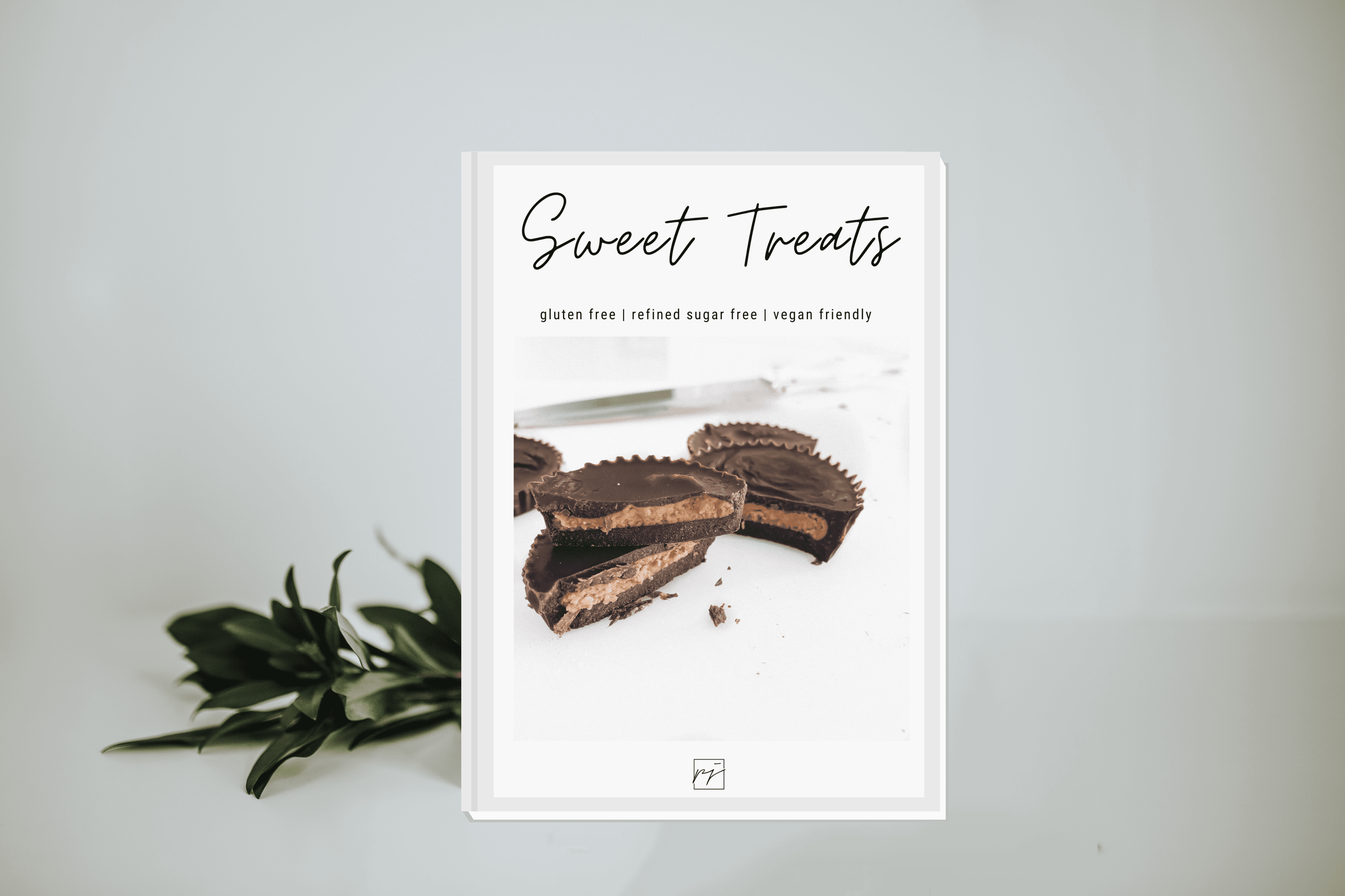 Sweet Treats E-Cookbook, gluten free, refined sugar free, vegan friendly. Chocolate peanut butter cups on a white backdrop with green foliage - lifewithPandJ